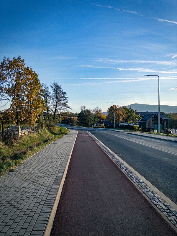 A scenic view of a pathway alongside a road during a morning walk.