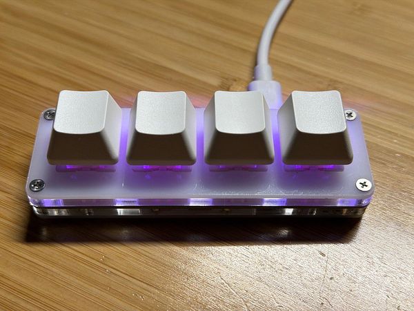 A custom four-button coding keyboard with illuminated keys.