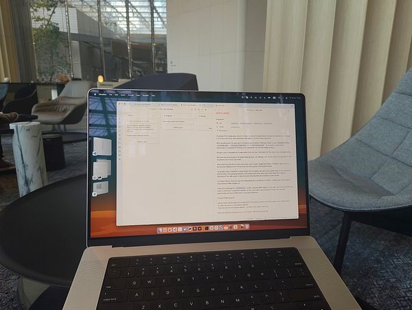 A laptop displaying a project management interface in a modern, stylish workspace.