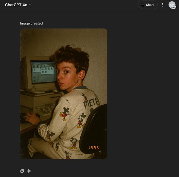 A young boy sits at a computer, wearing pajamas with a Mickey Mouse design.