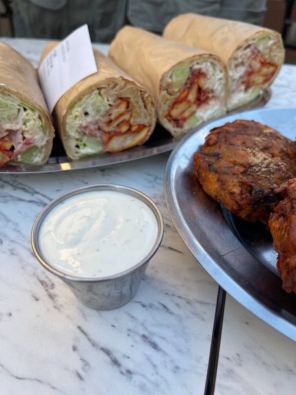 A plate featuring Indian-style wraps and a side of sauce.