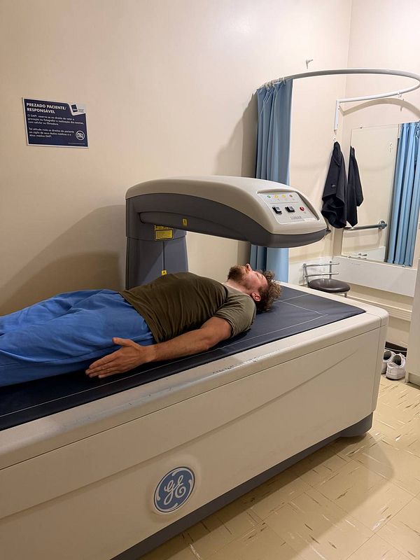 A photo of a DEXA scan device with a patient lying on the scanning table, taken during a first-time DEXA scan appointment.