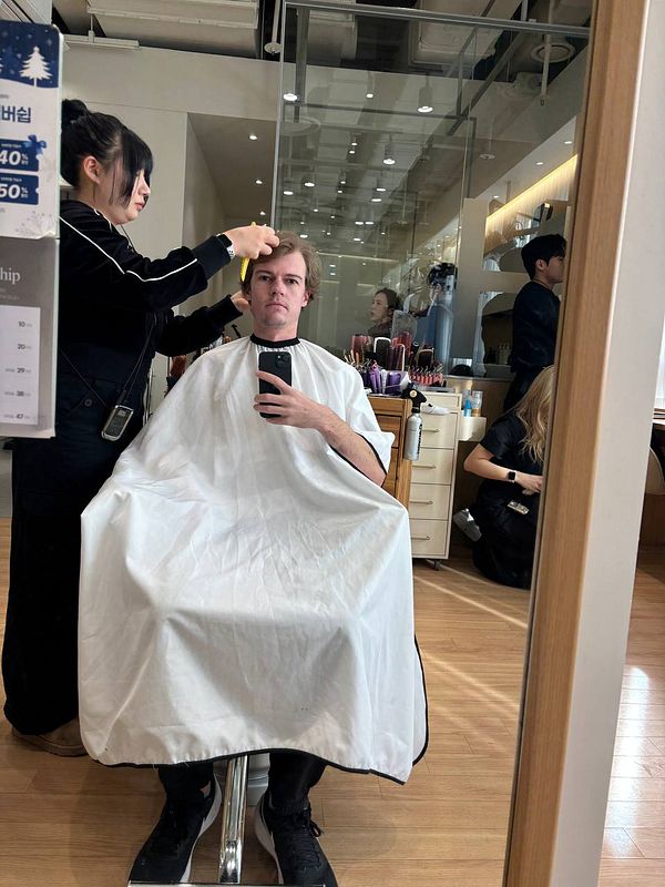 A person is getting a haircut in a salon.