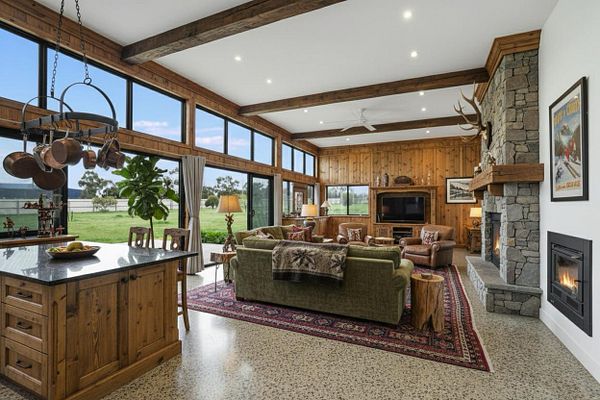 A spacious, modern living area with large windows and rustic decor.