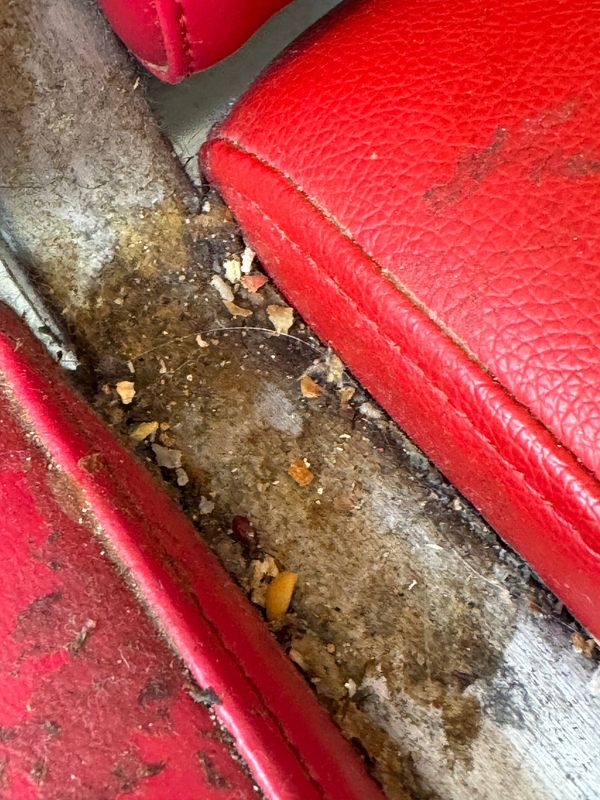 The image depicts a dirty and neglected seating area at Lisbon Airport.