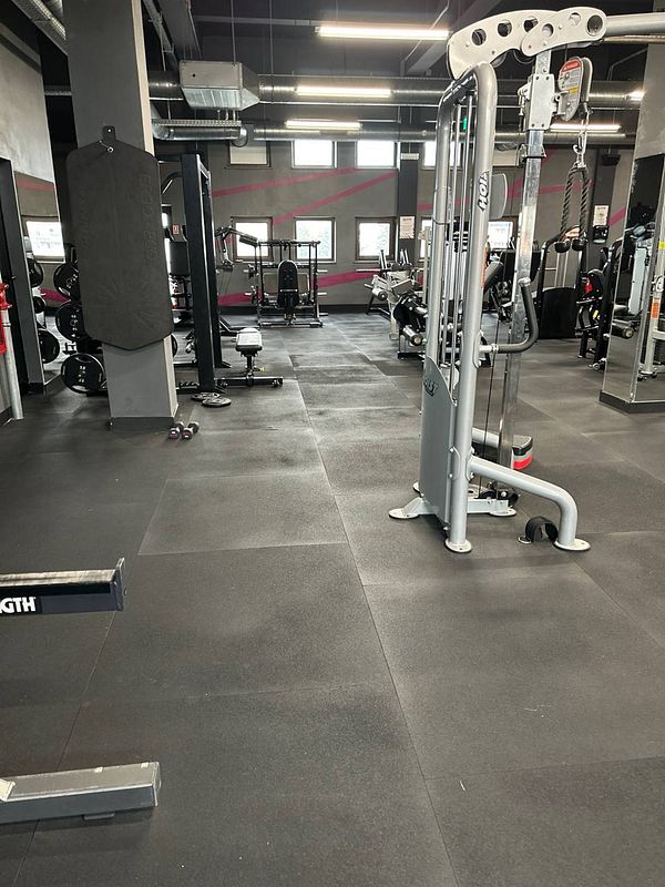 A spacious gym interior featuring various workout equipment.