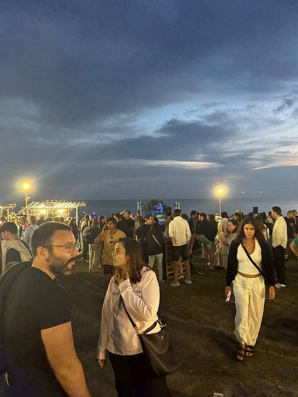 A lively outdoor festival scene at dusk with a crowd enjoying the Beerceira festival.
