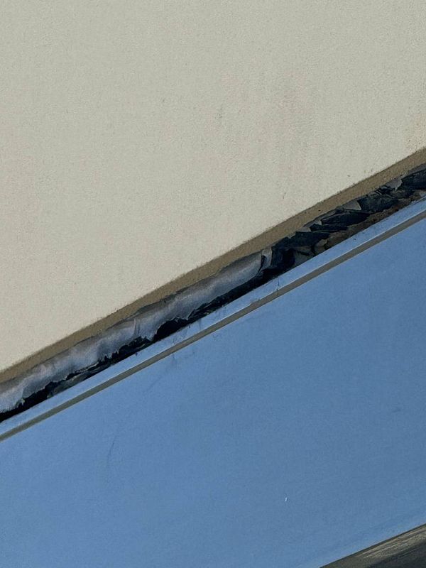 The image captures a close-up view of electric blinds that are partially lowered, revealing a gap at the top.