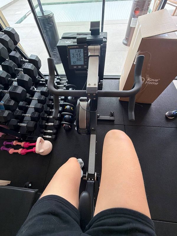 Photo of gym workout space with various exercise machines and a punching bag hanging from the ceiling.