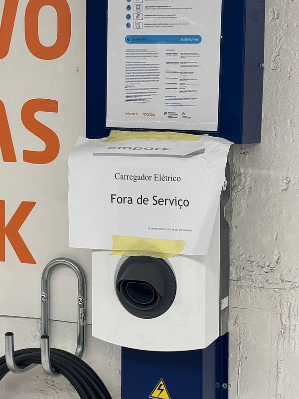 An electric vehicle charger is marked as out of service with a notice attached.