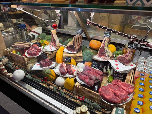 Grilled steak slices arranged on a wooden board alongside roasted vegetables and quinoa salad.