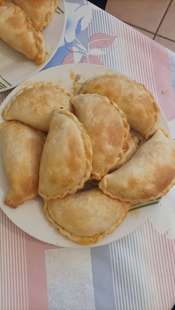 A plate of freshly made chicken empanadas is displayed.