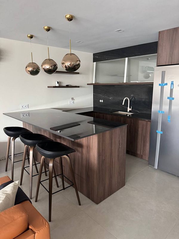 A modern kitchen area featuring a marble countertop and stylish decor.