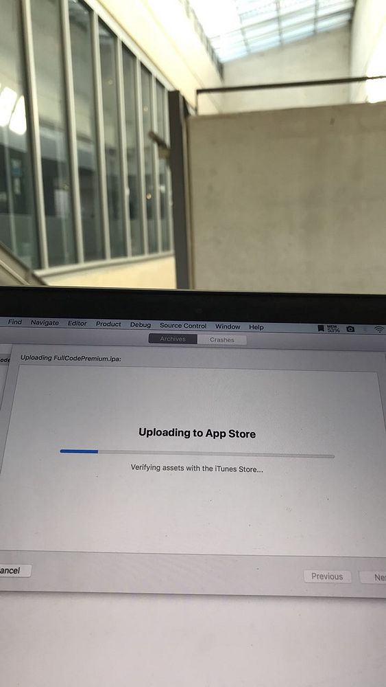 The image shows a computer screen with an app uploading to the App Store.
