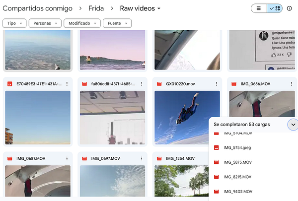 A woman wearing a brown hat and an orange long-sleeve top smiling while holding a slice of watermelon outdoors.