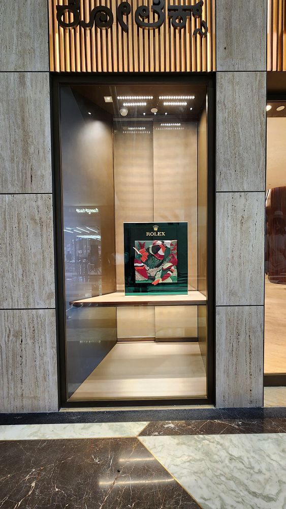 A display window of a new Rolex boutique featuring a decorative presentation.
