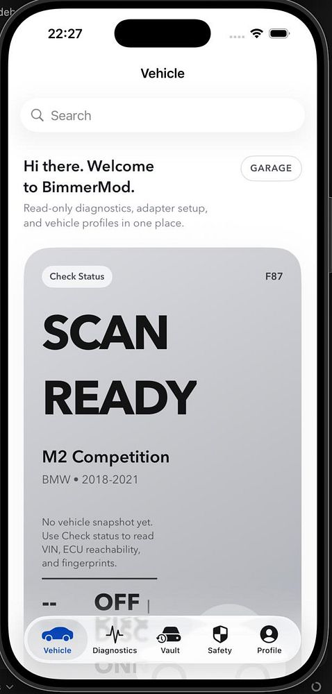 Vertical image of a white luxury BMW SUV driving on a mountainous road with dramatic clouds.