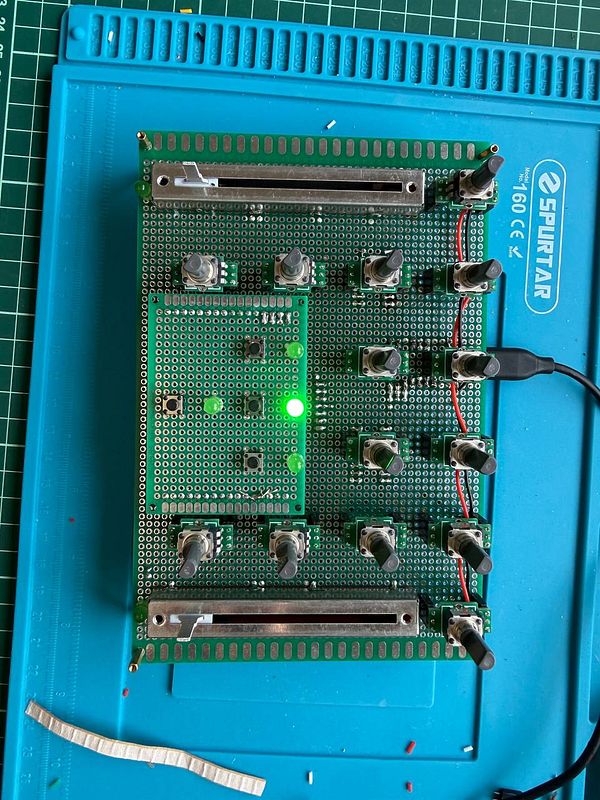 Close-up top view of a custom MIDI controller prototype with multiple knobs, buttons, and a fader, designed for mixer control.