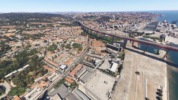 Aerial view of Lisbon showcasing urban areas, a bridge, and the waterfront.