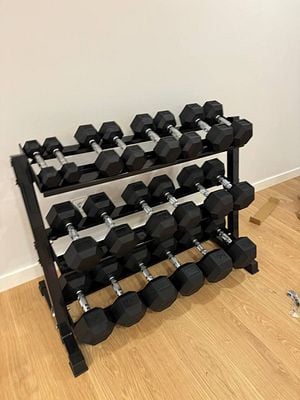 A neatly organized rack of hexagonal dumbbells in a home gym setting.