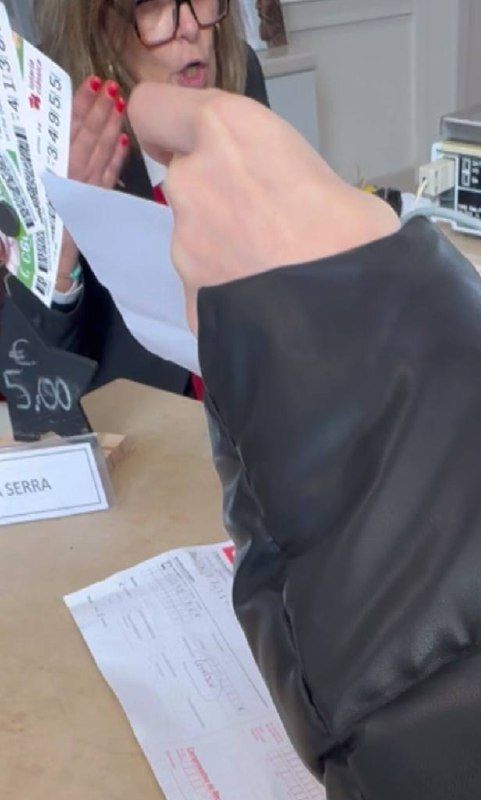 A customer is at a service counter discussing an issue with a staff member regarding package retrieval.