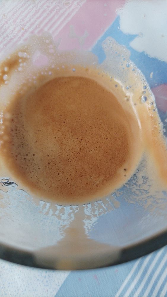 A close-up view of a glass containing freshly brewed espresso.