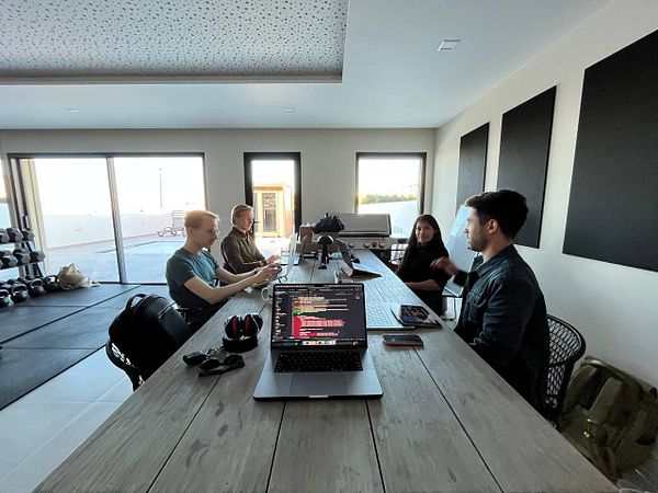 A group of four individuals is engaged in a coworking session at a modern workspace.