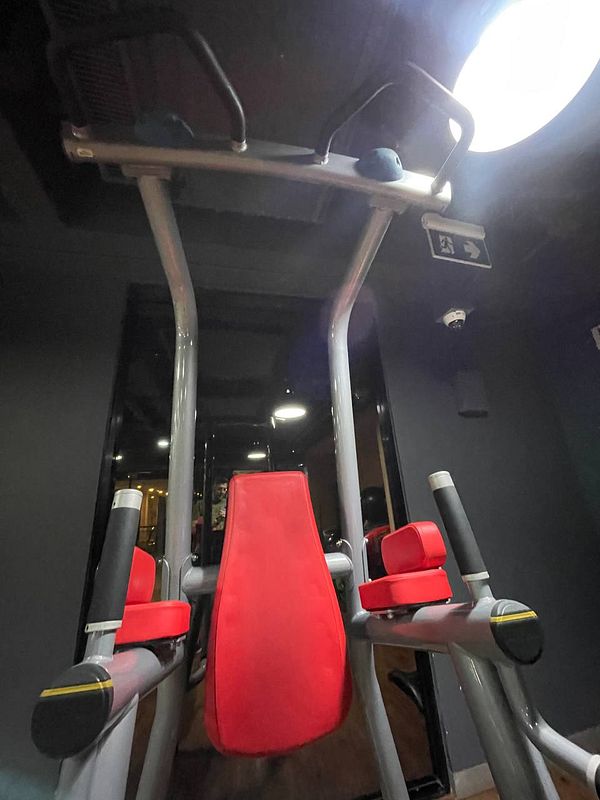 A gym equipment setup featuring a red and gray multi-functional machine.