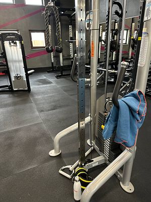 A gym interior featuring various exercise equipment and a towel.