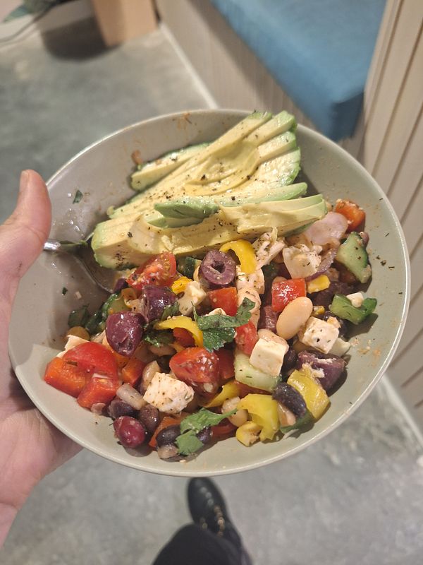 A kitchen counter displays a week's worth of meal prep containers filled primarily with oats and various fruits.