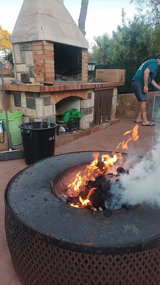 A backyard BBQ setup featuring a stone grill and a fire pit.