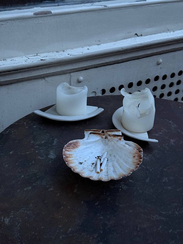 Romantic photo of a couple dining outdoors at a Parisian restaurant with a view of the Eiffel Tower at night.