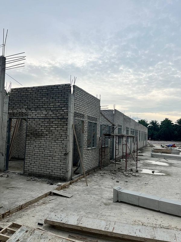 Construction site featuring partially built brick houses.