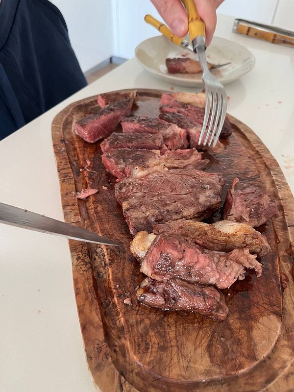 A beautifully cooked steak is displayed on a wooden cutting board, ready to be served.