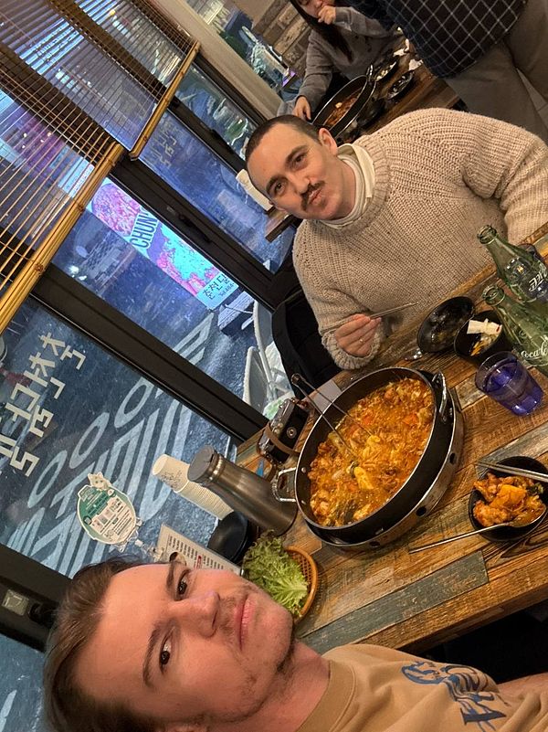 Two people are enjoying a meal of dakgalbi at a restaurant.