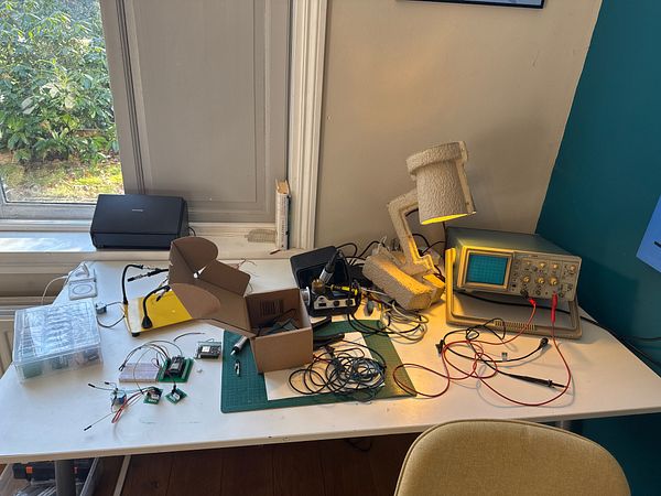 A cluttered workspace featuring various electronic components and tools for building temperature sensors.