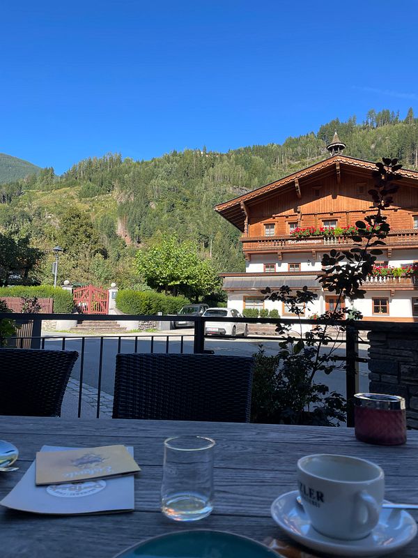 A scenic view from a café table overlooking a mountainous landscape.