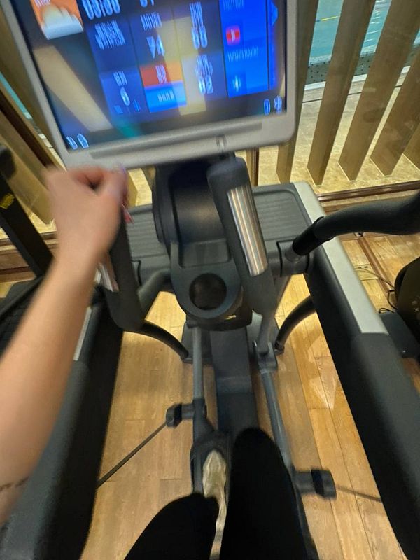 A person is exercising on an elliptical machine in a gym.