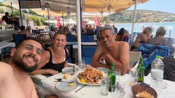A joyful family gathering at a beachside restaurant featuring a seafood feast.