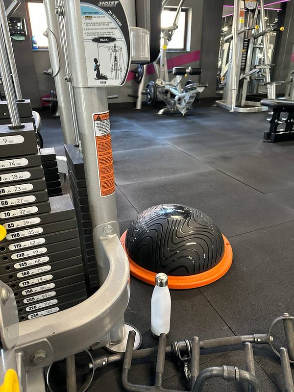 The image captures a gym interior featuring various exercise equipment.