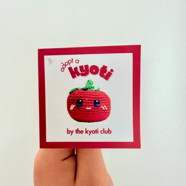 A colorful personality card featuring a cute crocheted tomato character.