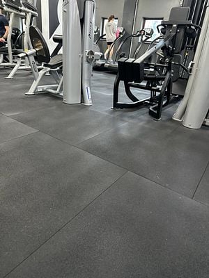 A gym interior featuring various exercise machines and equipment.