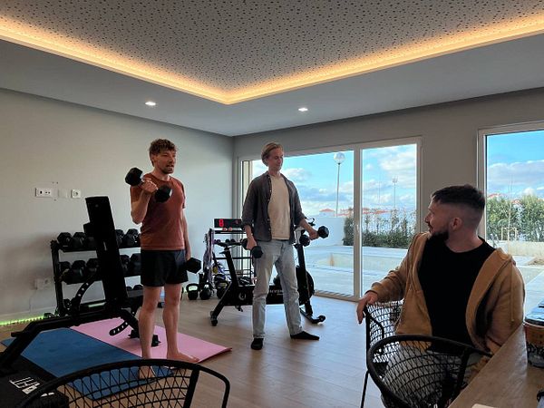 Three individuals are engaged in a fitness activity in a modern coworking space.