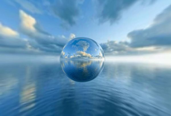 A panoramic photo of a mountainous desert landscape with a bright blue sky and scattered clouds.