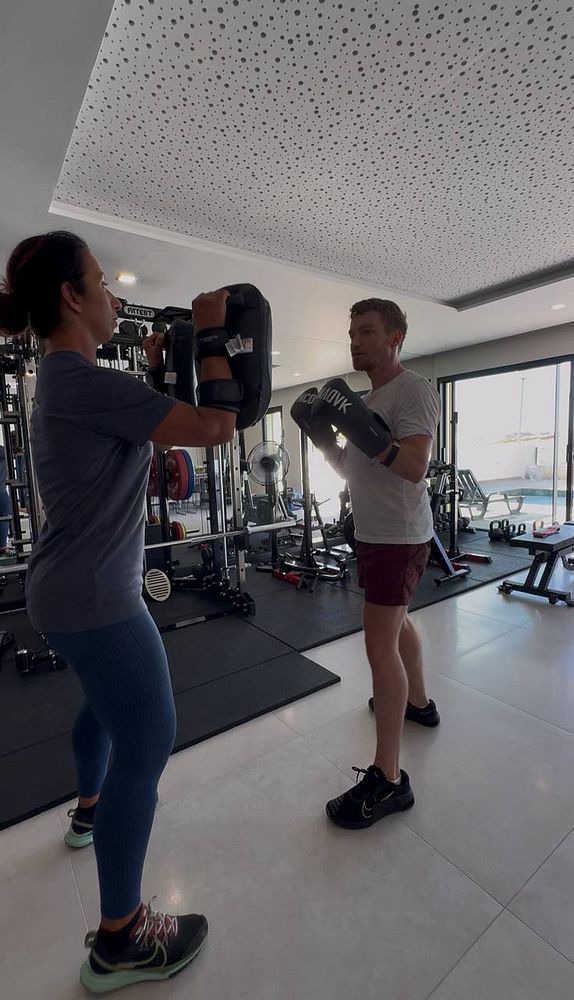 A personal training session is taking place in a gym setting.