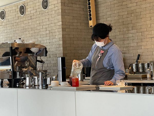 A barista prepares a drink at a modern coffee shop.