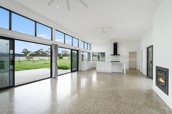 A spacious, modern interior of a home featuring large windows and a minimalist design.