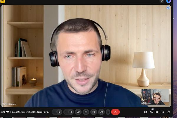 A person recording a podcast in a modern recording studio setup with microphones, headphones, and computers.