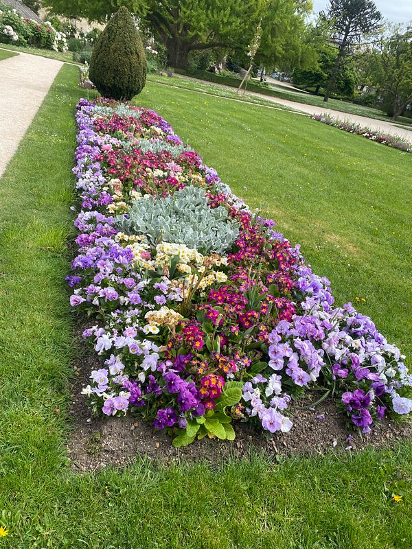 A vibrant, colorful painting of an abstract female figure surrounded by flowers.