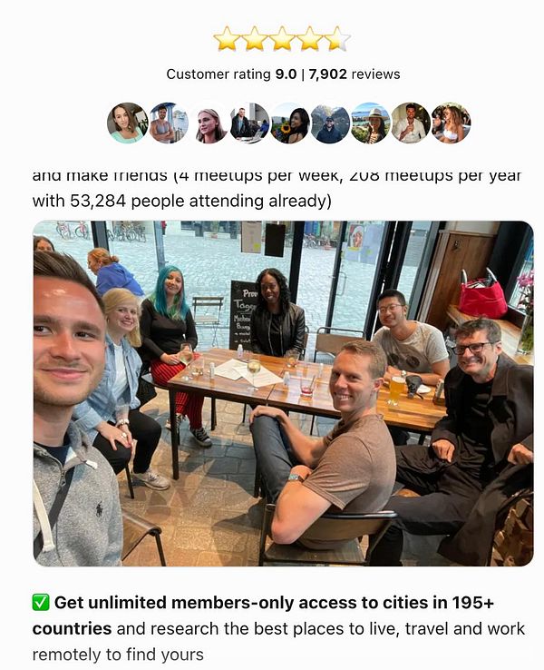 A group of six people is gathered around a table in a cafe, smiling and enjoying their time together.